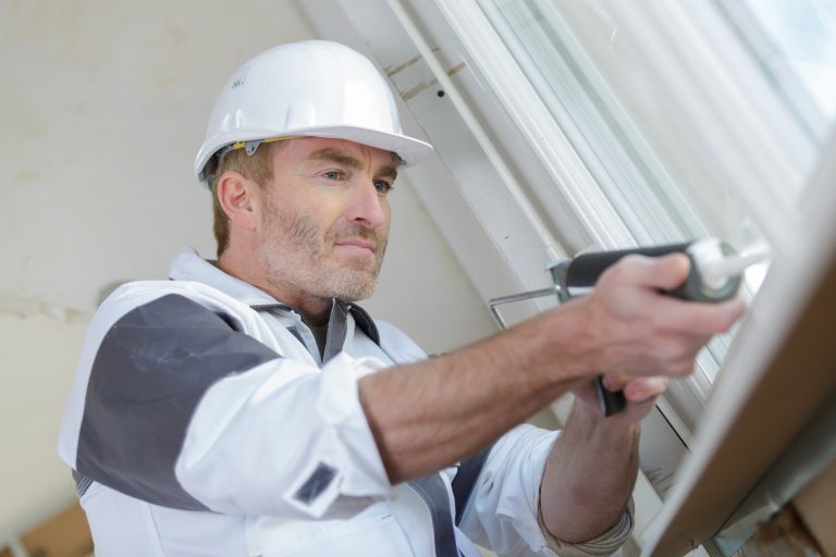 worker using a silicone to finish a patio